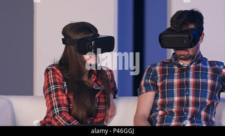 Junger Mann und Frau einstellen virtual reality Brillen Film ansehen Stockfoto