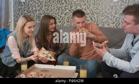 Gruppe von Freunden Pizza zum Mitnehmen essen und trinken Orangensaft Stockfoto