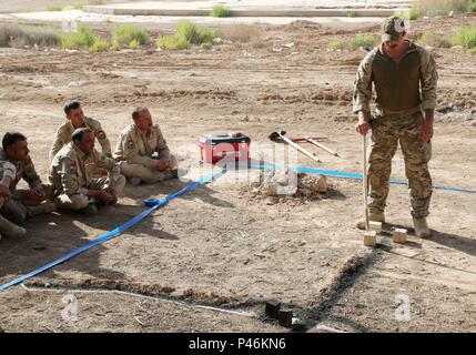 Britische Lance Cpl. Christopher Cooper, der Soldat mit dem Korps der Royal Engineers, erläutert die möglichen Bedrohungen im Irak Bundesgrenzschutz Polizisten Esel bei Explosionsgefahr awareness training auf al-Asad Air Base, Irak, 27. Juni 2016. EHAT Schulung wurde durchgeführt, um ein grundlegendes Verständnis von Improvised Explosive Device Einarbeitung und Nachweis zur Verfügung zu stellen. Die Schulung ist Teil des gesamten Combined Joint Task Force - inhärenten Building Partner Kapazität mission Lösen die Fähigkeit der irakischen Sicherheitskräfte im Kampf gegen die Islamischen Staat im Irak und der Levante zu erhöhen. Stockfoto