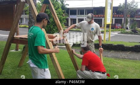 Ein technischer Assistent der 2. Klasse des Naval Mobile Construction Battalion 133 Civic Action Team Palau arbeitet mit lokalen Rotary Club Mitgliedern zusammen, um einen Spielplatz in Koror, Palau, am 25. Juni 2016 zu bauen. Das Projekt stärkt die Beziehungen zwischen den Gemeinden, bietet Freizeitinfrastruktur und veranschaulicht das Engagement und die Öffentlichkeitsarbeit der US Navy. Stockfoto