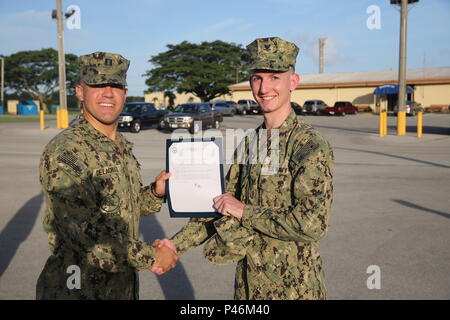 160628-N-ZZ 999-001 Santa Rita, Guam (28. Juni 2016) Elektroniker 3. Klasse Nicholas Hinton (rechts), zu Naval Mobile Konstruktion Bataillon 133 zugewiesen, erhält seinen frocking Brief von Leutnant Juan Delacruz (links), stellvertretender Offizier der Loslösung Guam, während einer Zeremonie frocking (U.S. Marine Foto von Elektroniker 3. Klasse Taylor Wells/Freigegeben) Stockfoto