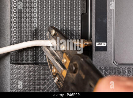 Ältere Menschen Hand schneiden Sie das Kabel auf seinem Kabel-TV-Paket Stockfoto