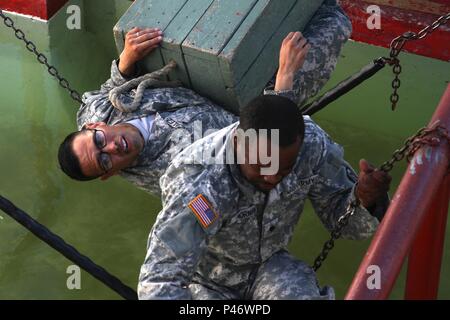 Sgt. Steven Gonzalez, ein stromgenerator Mechaniker den 1. Support Wartung Unternehmen, Fort Riley, Kansas, nutzt seinen Körper als Brücke eine Schachtel Munition über Wasser während der "besten Krieger Wettbewerb", 23. Juni 2016 an den Führern Reaktion Course, Fort Hood, Texas, zu erhalten. Gonzalez, ein Eingeborener von Nogales, Arizona, ist einer von zehn Soldaten im Wettbewerb um den Titel "Bester Krieger". Die Woche - lange Konkurrenz besteht aus sowohl psychische als auch physische Tests. (Foto von Sgt. Whitney Woods, 13. Öffentliche Angelegenheiten Abteilung) Stockfoto