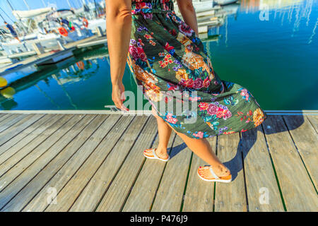 Detail der Beine der Frau zu Fuß auf hölzernen Steg der Marina de Lagos in Algarve, Portugal, Europa. Lifestyle Frau an der Bucht von Lagos in den Sommerferien. Stockfoto