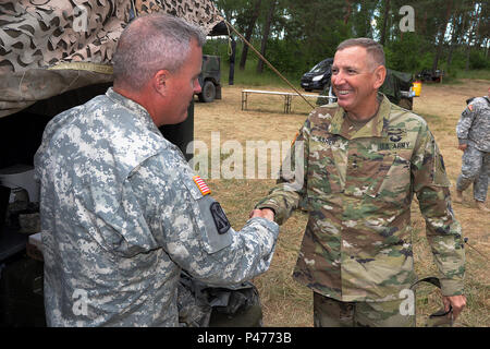 Us-Armee Oberstleutnant John Ebbighausen, Kommandant der 5. Bataillon, 113 Field Artillery Regiment (High Mobility Artillery Rocket System), North Carolina National Guard, begrüßt US-Armee Generalmajor Robbie L. Asher, der Adjutant General für die Oklahoma National Guard, bei Drawsco Pomorski Training Area, Polen, während der Übung Anakonda 16. Juni 9, 2016. Ein 16 ist eines der führenden multinationalen Ausbildung Veranstaltungen U.S. Army Europe. Es ist eine polnische Nationale Bewegung, die versucht, zu trainieren, Übung, und der polnischen nationalen Kommando- und Streitkrдftestrukturen in einen Alliierten, Gelenk, multinationalen Umfeld integrieren. Stockfoto