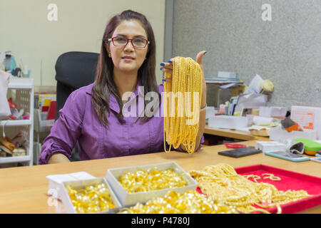 Asiatische reife Frau lächelnd Arbeiten in Gold shop besitzer. Stockfoto