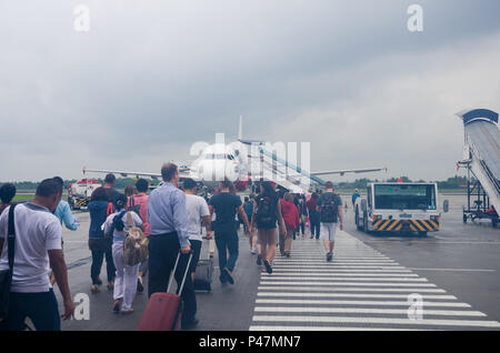 Menschen zu Fuß zum Flugzeug, Jakarta (Soekarno-Hatta Flughafen) nach Bali (Bali Ngurah Rai) Flug, Indonesien Stockfoto