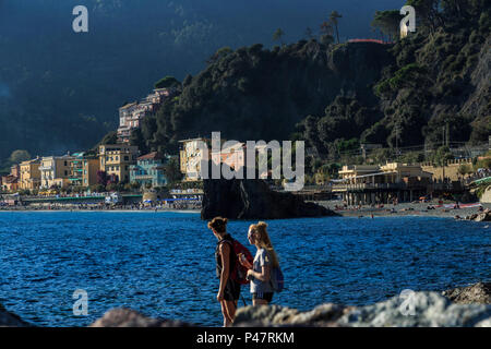 Zwei junge Frauen Touristen stehen auf Harbour Rocks am Meer, Monterosso, Cinque Terre Stockfoto