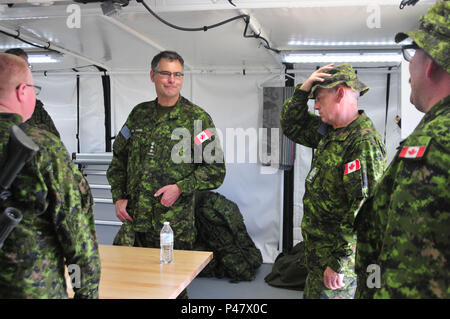 Kanadische Armee Oberst John Conrad und Canadian Army Chief Warrant Officer Brian Talty, Commander und Feuerwehr Sergeant Major von 41 kanadischen Brigade Group neue Kanadische militärischer Technologie an Operating Base Custer, Custer, S.D., 15. Juni 2016 erörtern. Die goldenen Coyote Übung ist eine dreiphasige, Szenario-driven Übung in den Black Hills von South Dakota und Wyoming, mit dem Kommandanten auf der Mission wesentliche Anforderungen der Aufgabe, Krieger Aufgaben und Übungen zu konzentrieren. (U.S. Armee Foto von SPC. Robert West/Freigegeben) Stockfoto