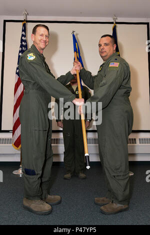 Colonel Bryan White, 168 Operationen Gruppenkommandant, Hände die 168 Air Refuelling Squadron guidon, Oberstleutnant Jhonny Polanco, während der Annahme des Befehls Trauung im Innern Auditorium des Konzerns auf Eielson AFB, Alaska, 27. Dezember 2016. Polanco übernimmt das Kommando über die Staffel nach dem Rücktritt seines Vorgängers, Oberstleutnant Buck Smith, der von der Air National Guard Interior-Alaska Flügel Anfang dieses Monats in den Ruhestand. (U.S. Air National Guard Foto von Senior Master Sgt. Paul Mann/Freigegeben) Stockfoto