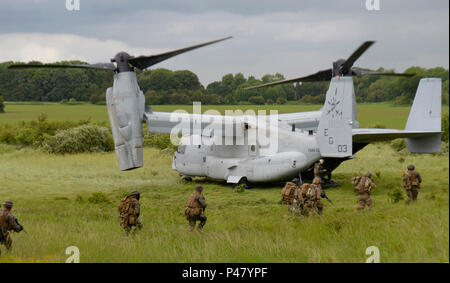 Us-Militär Mitglieder vorzubereiten Board eine MV-22 Osprey nach Abschluss einer gemeinsamen Übung an der Stanford Training Area, England, Juni 14. 57 Rescue Squadron pararescuemen, zusammen mit US-Marines und Matrosen der Special-Purpose Marine Air-Ground Task Force Crisis Response Afrika Unit, zusammen trainiert Einblick auf die Zusammenarbeit downrange zu gewinnen. (U.S. Air Force Foto/Airman 1st Class Abby L. Finkel) Stockfoto