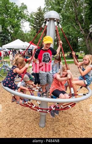 Junge Kinder Spinnen auf dem Spielplatz Merry-go-round, Salida, Colorado, USA Stockfoto