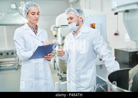 Professionelle Konditoren diskutieren in der Factory Stockfoto