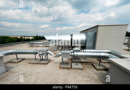 Elemente von Lüftung und Klimaanlage auf dem Dach eines Mehrfamilienhauses platziert Stockfoto