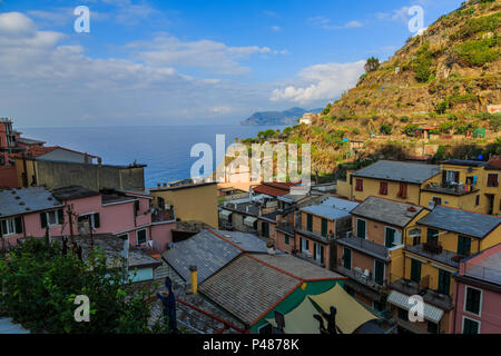 Bunte Häuser am späten Nachmittag Sonne und Schatten mit Blick auf das Meer und Himmel, Manarola, Cinque Terre Stockfoto