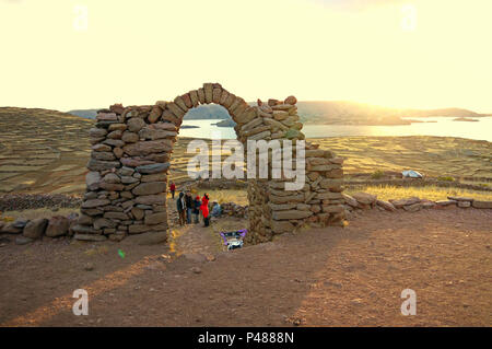 Einheimische und Touristen einfinden, um die schönen bunten Sonnenuntergang über den Titicacasee von einer Insel Taquile in Peru zu sehen, aber auf der Suche nach Bolivien. Stockfoto