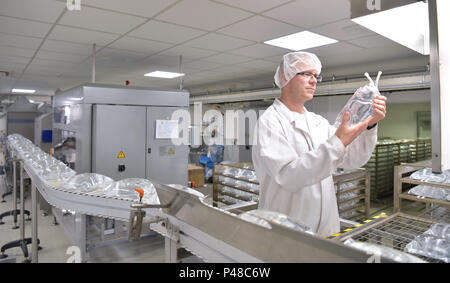 Arbeitnehmer in sterilen Schutzkleidung für die Kontrolle der Qualität von Insulin Infusion Taschen in einer Fabrik Stockfoto