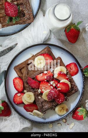 Hausgemachte Schokolade Waffeln mit frischen Beeren und Bananen Stockfoto