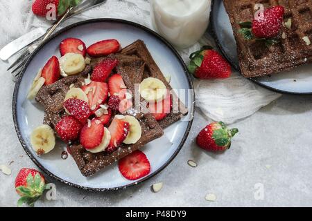 Hausgemachte Schokolade Waffeln mit frischen Beeren und Bananen Stockfoto