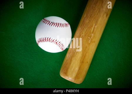 White baseball ball und Holz- bit auf grünem Filz Hintergrund isoliert Stockfoto