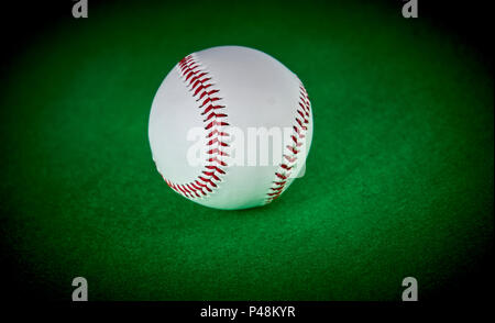 Baseball Ball auf grünem Filz Hintergrund isoliert Stockfoto