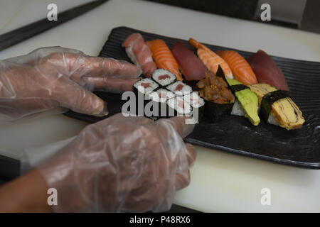 Chef arrangieren Sushi in einem Fach Stockfoto