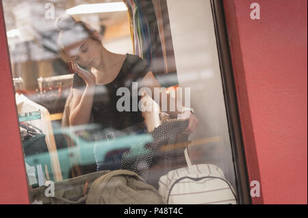 Schöne Frau Gespräch am Handy während des Einkaufs Stockfoto