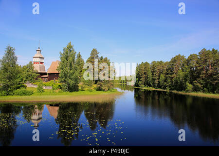 Finnische blauen See und Himmel Landschaft mit UNESCO-Weltkulturerbe, alte hölzerne Kirche von Petajavesi, Finnland im Sommer. Die Kirche wurde 1763-65 erbaut. Stockfoto