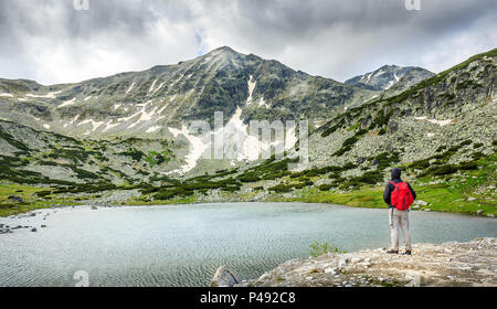 Wanderer auf der Suche nach wunderschönen Rila-Gebirge See und verschneite Mussala Gipfel an einem bewölkten, dramatischen Tag Stockfoto