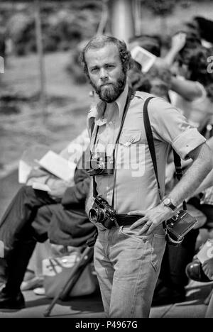 FORT SMITH, AR, USA - 10. AUGUST 1975 -- Pulitzer Prize Fotojournalist David Hume Kennerly bereitet eine Rede von Präsident Gerald Ford im neuen Vietnamesischen Flüchtlingslager am Fort Chaffee, AR zu decken. Kennerly, wer gewann den Pulitzer-preis Für sein Foto Abdeckung der Vietnamkrieg war offizielle White House Fotografen von Ford. Stockfoto