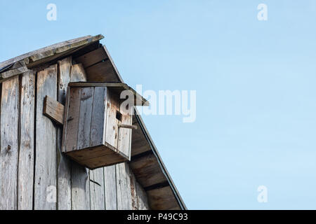 Holz- birdhouse auf einer hölzernen Scheune Wand in einem ländlichen Gebiet Stockfoto