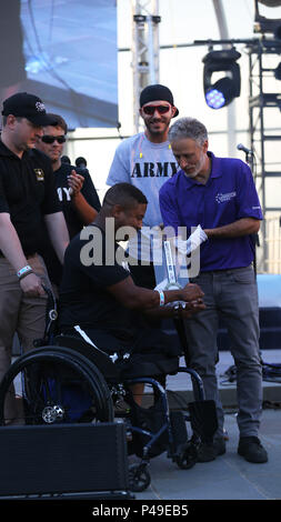 Komiker Jon Stewart, präsentiert das "Herz der Award das Team "U.S. Army Veteran, Sgt. Ryan Major, von Baltimore, Maryland, während die Abteilung 2016 der Verteidigung Krieger spiele Closing Ceremony, Trophäe, an der United States Military Academy, West Point, New York, Juni 21. (U.S. Armee Foto von Pfc. Stefan Englisch/Freigegeben) Stockfoto