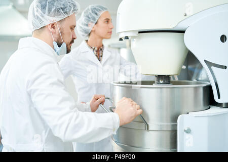 Zwei Süßwarenfabrik Arbeiter Bedienen von Maschinen Stockfoto