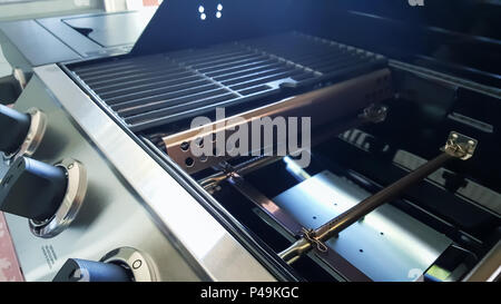 Nahaufnahme von Gas Grill Brenner, flavorizer Bars, porcelanized Gusseisen Grids und CONTROL-Knöpfe. Stockfoto