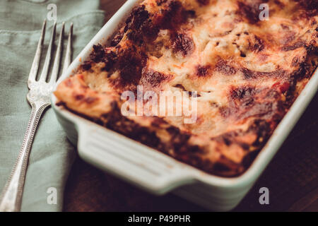 Italienische Lasagne Bolognese und Mozzarella auf rustikalen dunklen Hintergrund Stockfoto