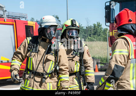 Zivile Feuerwehrmänner Sascha Schubert, links, von der Feuerwehr Ansbach, und Werner Deppisch, Rechts, von der Illesheim Feuerwehr, nehmen teil an ihren jährlichen aus verunfallten Fahrzeugen Training am Urlas Feuerwehr Training Center in Ansbach, Deutschland, 23. Juni 2016. Der Zweck der Rettung aus verunfallten Fahrzeugen Schulung ist der Zugang zu den Betroffenen in das Innere des Autos zu gewinnen. (U.S. Armee Foto von visuellen Informationen Spezialist Georgios Moumoulidis/freigegeben) Stockfoto