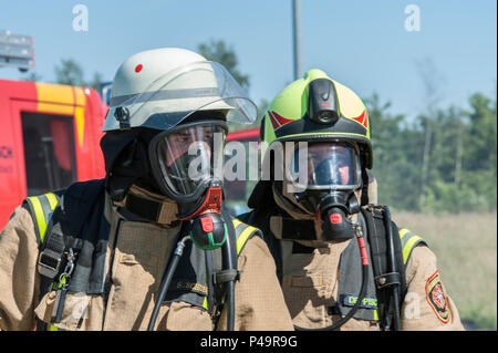 Zivile Feuerwehrmänner Sascha Schubert, links, von der Feuerwehr Ansbach, und Werner Deppisch, Rechts, von der Illesheim Feuerwehr, nehmen teil an ihren jährlichen aus verunfallten Fahrzeugen Training am Urlas Feuerwehr Training Center in Ansbach, Deutschland, 23. Juni 2016. Der Zweck der Rettung aus verunfallten Fahrzeugen Schulung ist der Zugang zu den Betroffenen in das Innere des Autos zu gewinnen. (U.S. Armee Foto von visuellen Informationen Spezialist Georgios Moumoulidis/freigegeben) Stockfoto