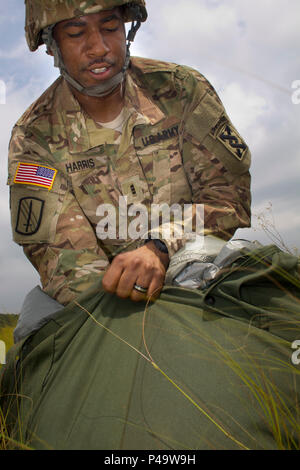 Chief Warrant Officer John Harris III, 824Th Quartermaster Unternehmen, packt sein Fallschirm nach einem erfolgreichen Sprung auf St. Mere Eglise Drop Zone in der Nähe von Fort Bragg, N.C. am 25. Juni 2016. Die 824Th support für den Betrieb zur Verfügung gestellt, der von der US-Armee die zivilen Angelegenheiten & psychologische Operations Command (Airborne). USACAPOC (A), eine Armee finden Einheit, führt luftgestützten Hilfsaktionen in der Auftragswährung und Leistungsfähigkeit zu erhalten. USACAPOC (A) unterstützt die Armee und der gemeinsamen Kraft mit strategischen, operativen und taktischen zivilen Angelegenheiten, militärische Informationen Support und Information Funktionen acr Stockfoto