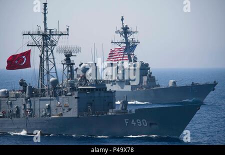 Die türkische G-Klasse Fregatte TCG Gaziantep (F-490) ist im Gange, die sich in der Ausbildung mit der Arleigh-Burke-Klasse geführte Anti-raketen-Zerstörer USS Donald Cook (DDG75) während einer Übung mit den türkischen und den United States Marine im Mittelmeer, 25. Juni 2016. (U.S. Marine Foto von Mass Communication Specialist 3. Klasse J. Alexander Delgado) Stockfoto