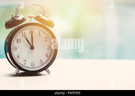 11 o'clock retro Clock am Swimmingpool Outdoor Urlaub Zeit Zeit Konzept entspannen. Stockfoto