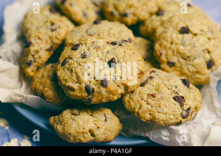 Frisch gebackene Oatmeal Chocolate Chip Cookies auf blauem Hintergrund Stockfoto