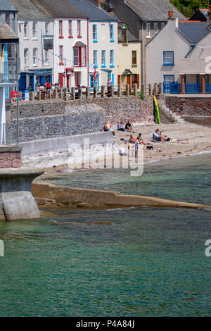 Strandurlauber und Trinker den Sommer genießen Wetter an der Küste Fischerdorf Kingsand in Cornwall an einem heissen Sommertag, Cornwall, Großbritannien Stockfoto