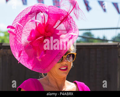 Ascot, Berkshire, Großbritannien. 21st. Juni 2018. Racegoers kommen in Ascot in ihren Hüten und Raffinerie für Ladies Day in Royal Ascot, während sie ihren Weg zu der Veranstaltung machen. Fashion on Ladies Day Royal Ascot - Frau trägt rosa Hut, rosa Lippenstift und Sonnenbrille. Quelle: Carolyn Jenkins/Alamy Live News Stockfoto