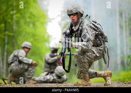 Armee Pfc. Richard Burger, ein Eingeborener von Unabhängigkeit, MO, der 574Th Quartermaster Firma zugewiesen, 17. Bekämpfung der Erhaltung Unterstützung Bataillon, U.S. Army Alaska, zieht die Sicherheit als Kameraden, ärztliche Behandlung zu einem simulierten Unfall auf eine Situation Übung Training Lane während der Bereit Krieger Wettbewerb im Camp Madbull auf gemeinsamer Basis Elmendorf-Richardson, Alaska, Donnerstag, 23. Juni 2016. Der dreitägigen Wettbewerb Teams von Soldaten in die körperliche Fitness getestet, Kleinwaffen proficiency, Land, Navigation, und kleine Einheit Taktiken sowie die anderen Soldaten Fähigkeiten. (U.S. Air Force Foto/J Stockfoto