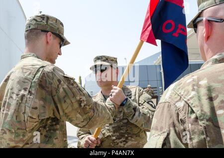 Kapitän Marc Eskew, ausgehende Commander der Firma, Sitz und Hauptverwaltung Bataillon, Luftlandedivision (Air Assault) übergibt das Unternehmen guidon, Oberstleutnant Nikolaus Guran, HHB Commander, bei einem Wechsel des Befehls Zeremonie in Erbil, Irak, 27. Juni 2016. Die Weitergabe der Ops. Co.GUIDON zwischen Ihnen symbolisiert den Befehl Eskew aufzugeben. Ops. Amazon.de mission beinhaltet, der Bürgermeister und der Streik Zellen am Leben Support Bereich Gefahr in der Unterstützung von Combined Joint Forces Land Component Command-Betrieb inhärenten Lösen. (U.S. Armee Foto: Staff Sgt. Peter J. Berardi) Stockfoto