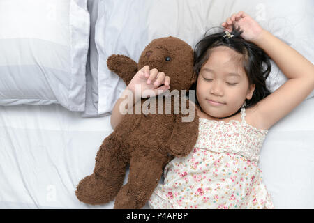 Süße kleine Mädchen schläft im Bett mit einem Spielzeug Teddybär, Entspannung und Erholung Konzept Stockfoto