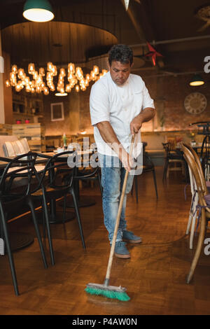 Männliche baker Reinigung Boden mit Mop Stockfoto