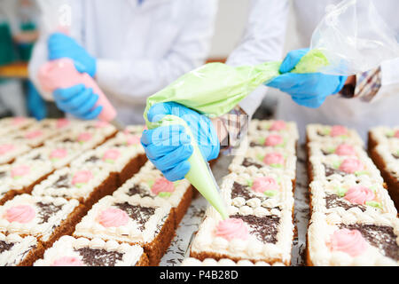 Kuchen dekorieren in der Süßwarenfabrik Stockfoto