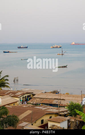 Blick über die Slums von Freetown am Meer, wo die armen Bewohner der Afrikanischen Hauptstadt leben mit Schiffe und Boote in der Bucht, Sierra Leone, Afr Stockfoto