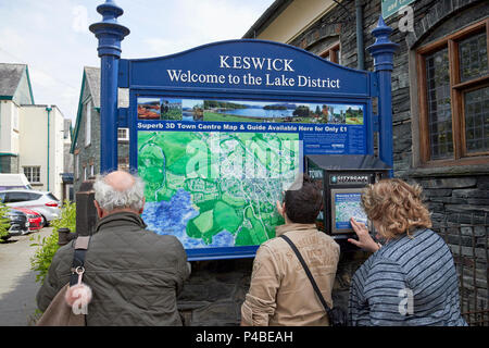 Ausländische Touristen Prüfung eine Karte der Stadt Keswick Cumbria Lake District England Großbritannien Stockfoto